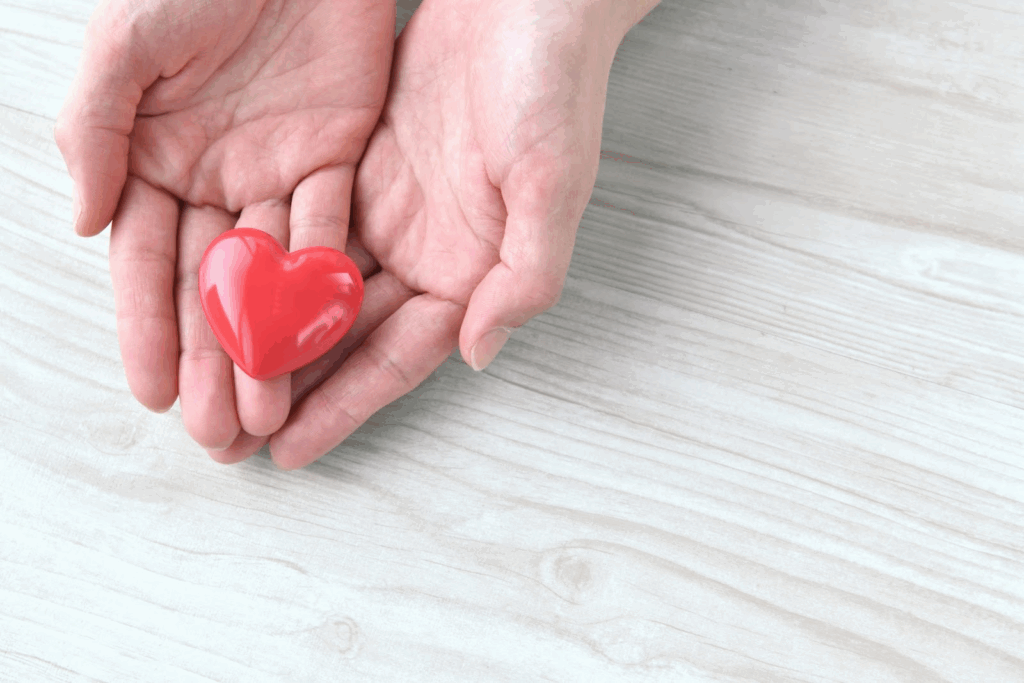 Hands gently holding a red heart shape.: Tara Brach