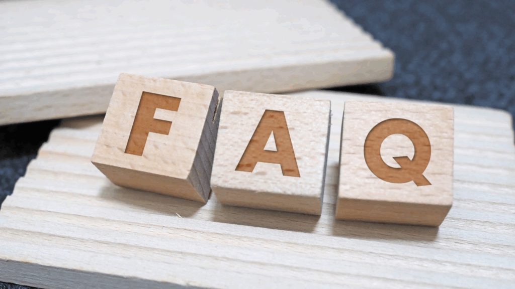 Wooden letter blocks spelling out 'FAQ' placed on a wooden surface.