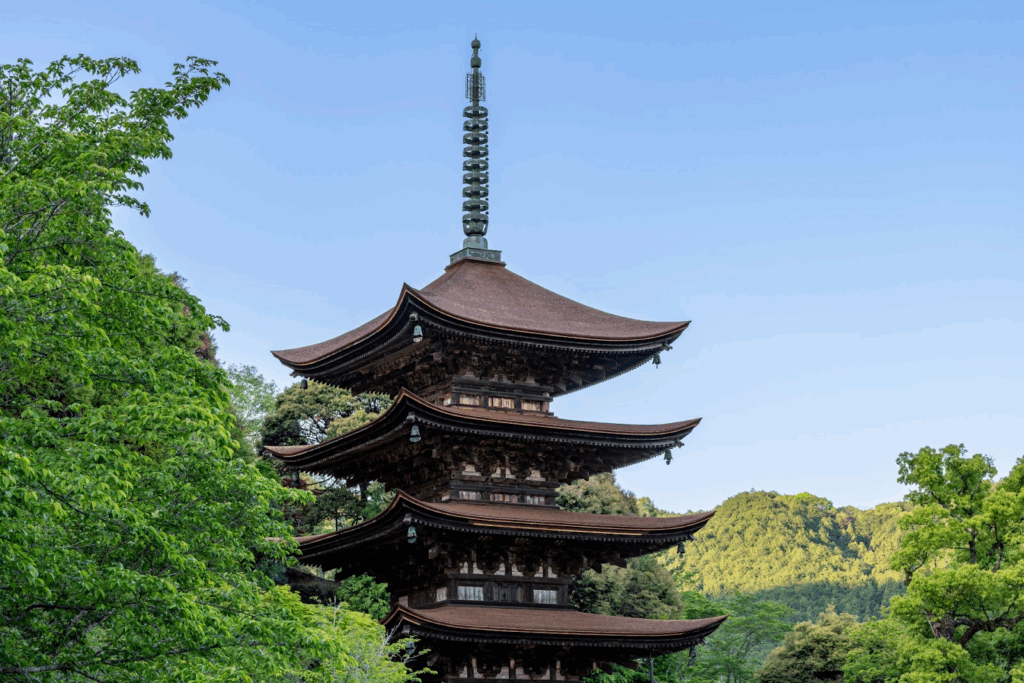 A traditional Japanese five-story pagoda surrounded by lush green trees with a clear 
blue sky in the background.:Meditation for Anxiety