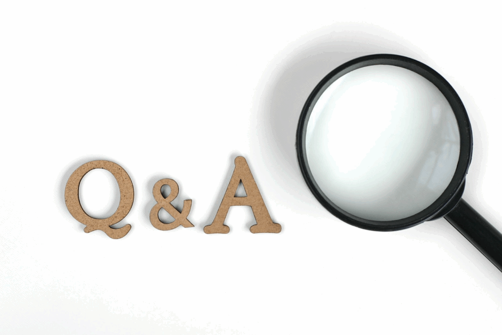 白い背景の上に置かれた『Q&A』の木製文字と虫眼鏡。:仏教瞑想