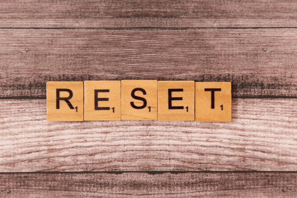 The word "RESET" spelled out with wooden letter blocks on a wooden background, symbolizing restart or a fresh beginning. :Meditation Retreat