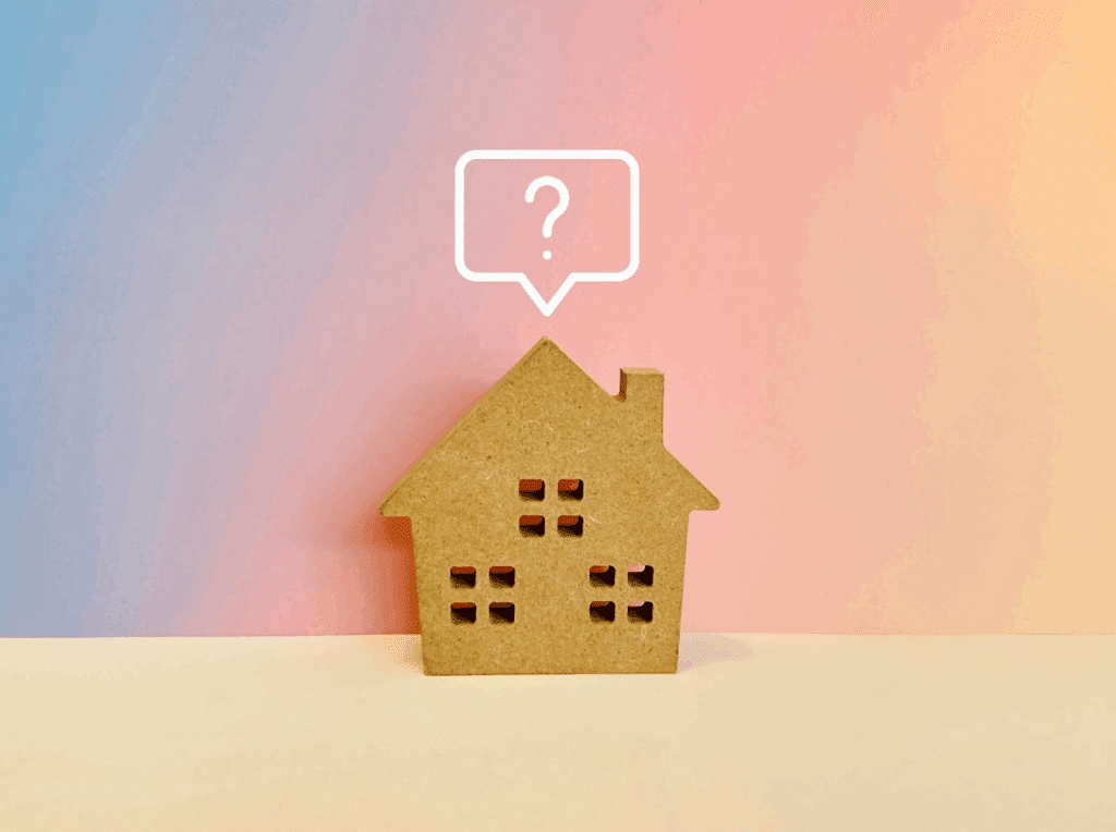 A wooden house-shaped object placed in front of a colorful background. Above it, a speech bubble with a question mark suggests uncertainty or questions about housing. :Meditation Retreat