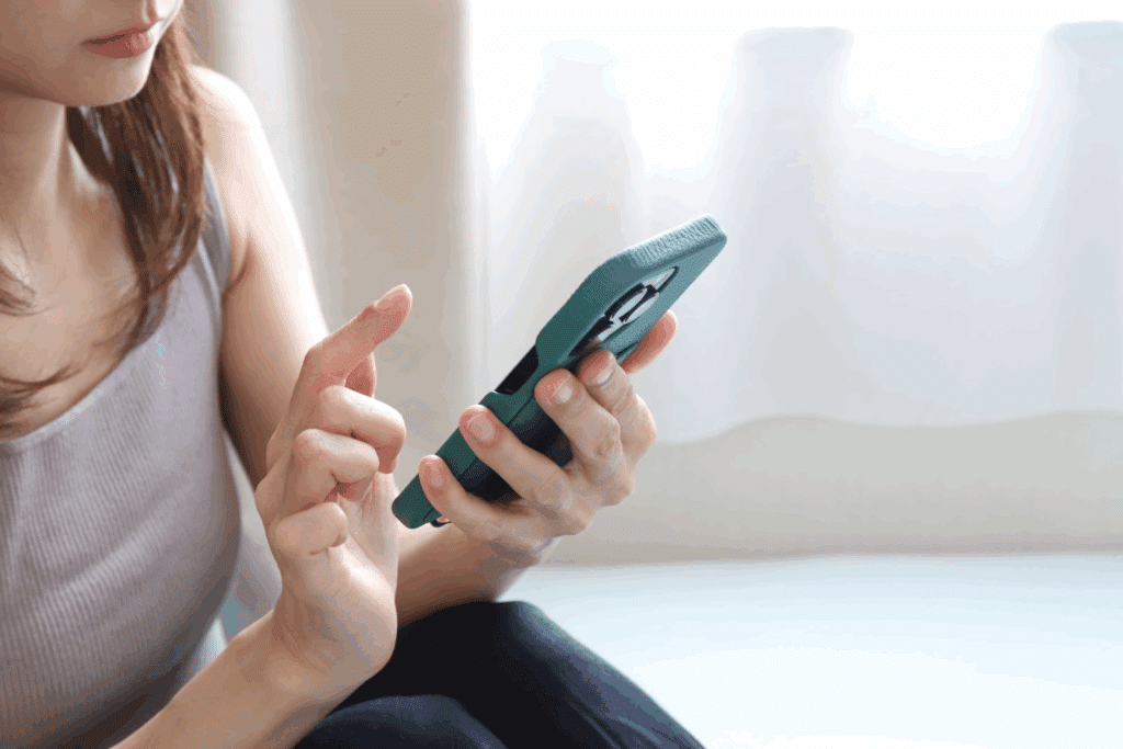 Close-up of a woman holding a smartphone and operating the screen, focusing on checking messages or apps :Meditation Center