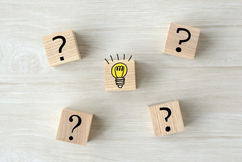 Wooden blocks with four question marks surrounding a central block with a light bulb, symbolizing the moment of finding an idea or solution : Body Scan Meditation