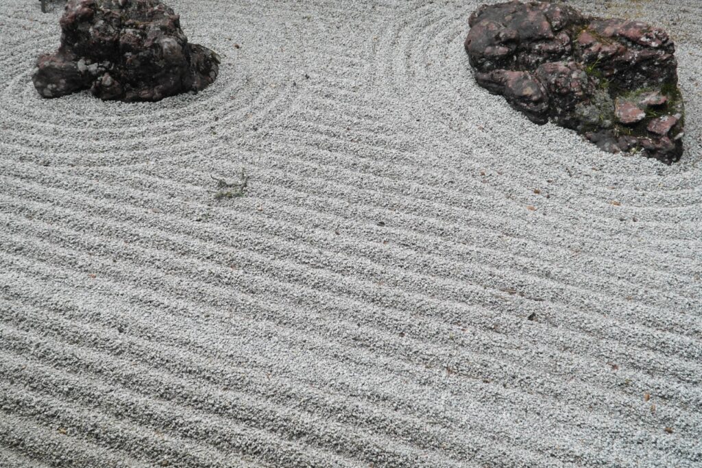 A Japanese Zen garden with rocks and carefully raked white gravel patterns :Meditation for Anxiety