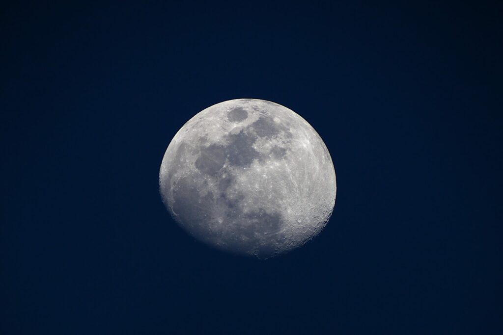 夜空に浮かぶ月のクローズアップ写真。クレーターや表面の模様がはっきりと見える:睡眠催眠