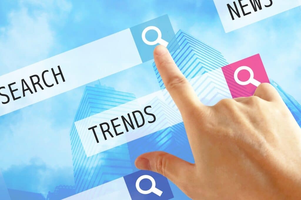 A hand tapping a digital “TRENDS” search button on a screen interface, with a cityscape background — symbolizing online search, trend analysis, and digital information gathering: Mindfulness Journal