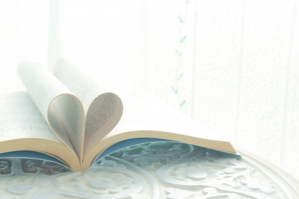 本のページがハート型になるように折られ、柔らかな光の中に置かれている：不安