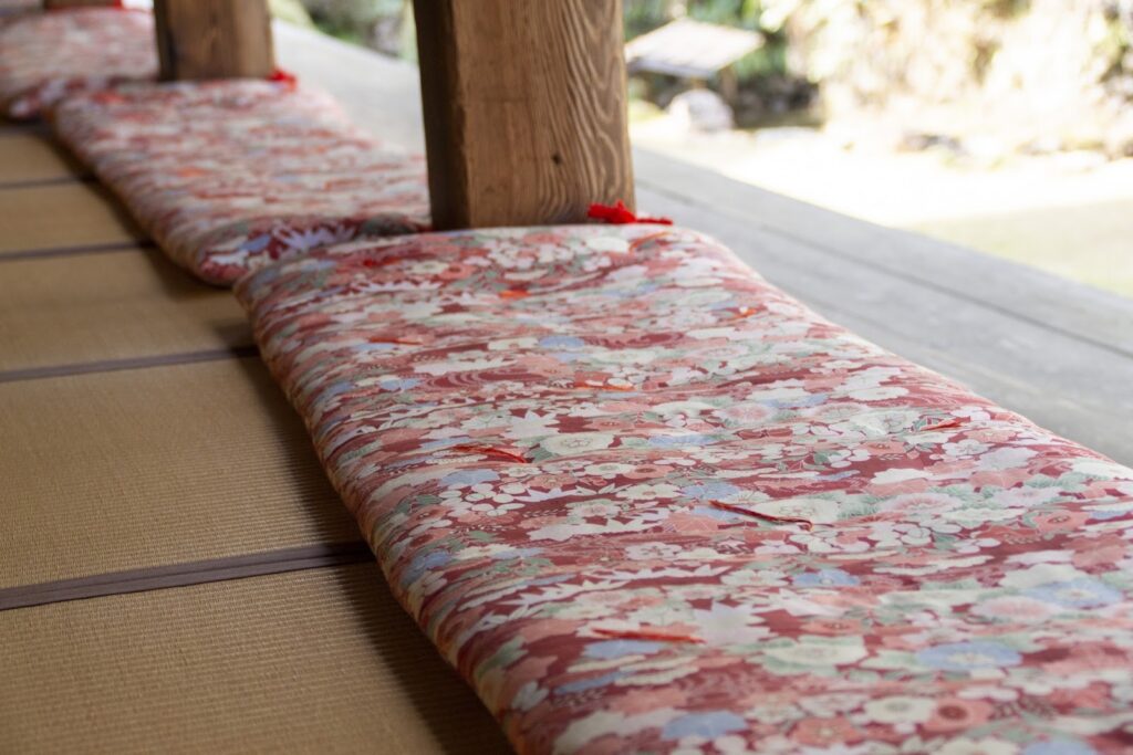 縁側に並べて置かれた花柄の座布団。畳と木の柱が温かな和の風情をつくり出している:座布団